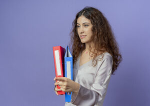 A young woman holding red and blue folders, representing organization and academic success, symbolizing the structured and innovative approach of Dutch education.