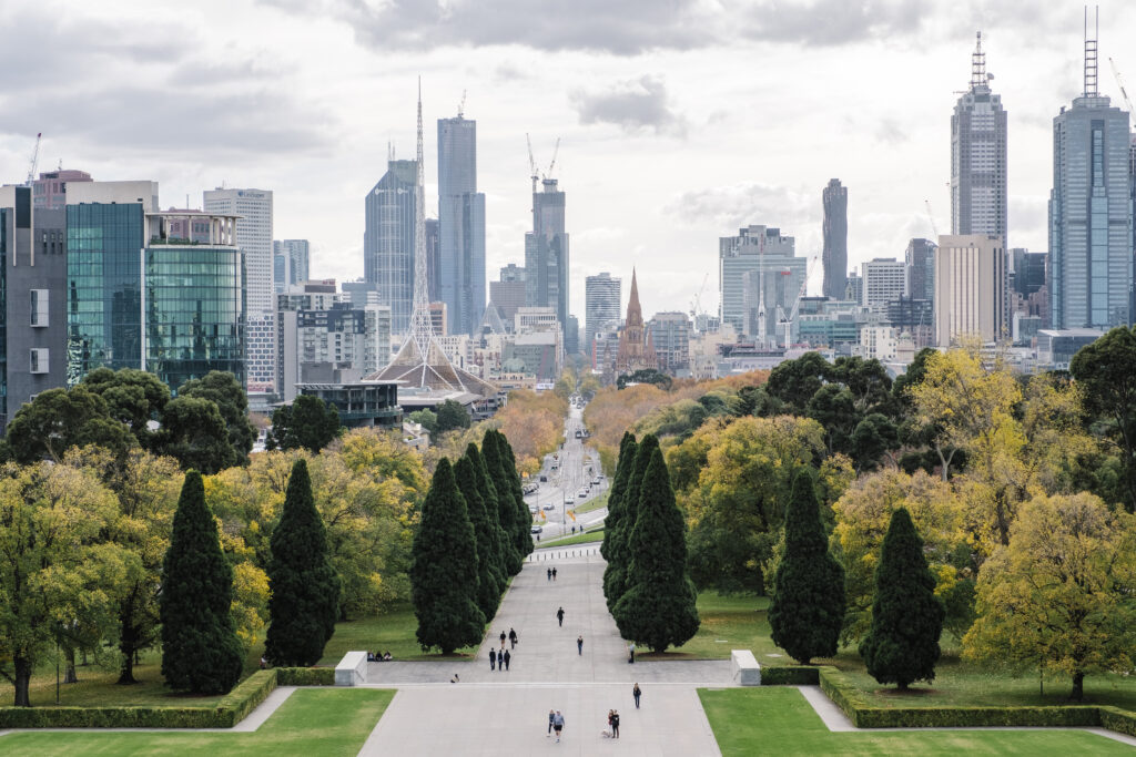 Scenic view of a cityscape with modern skyscrapers and lush greenery, representing New Zealand's cities.