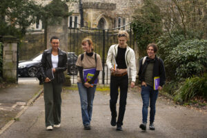 A group of diverse students walking together on a university campus, carrying books and notebooks, symbolizing the journey of Dutch Universities and Programs through exploration and academic choices.