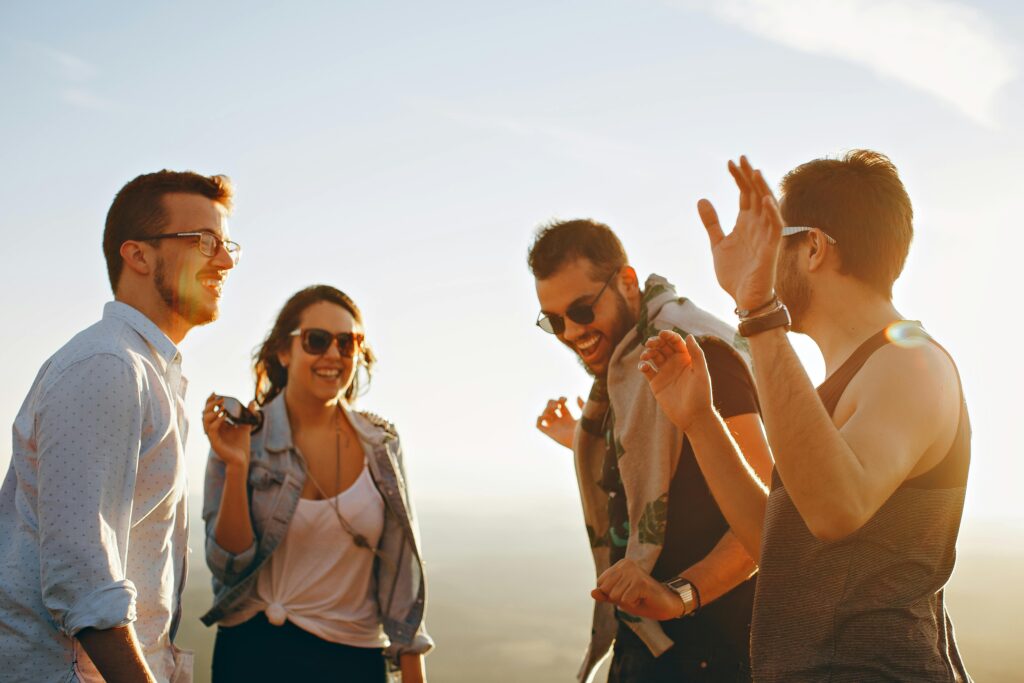 Group of young adults laughing and enjoying time together outdoors, representing social life in the USA for international students.