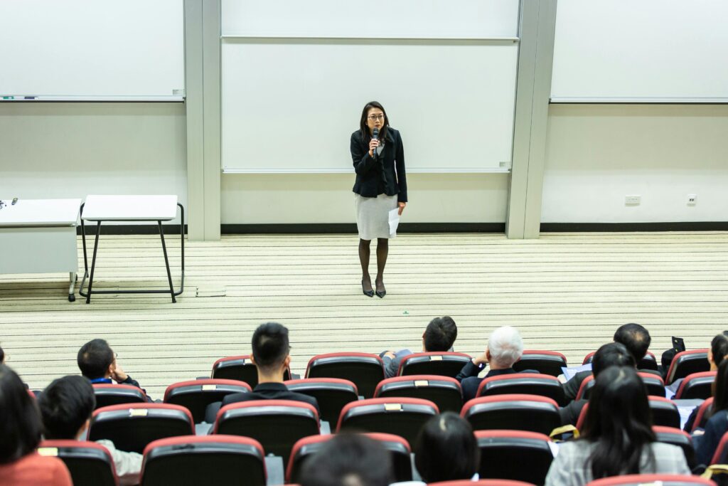 Businesswoman giving presentation to audience in lecture hall