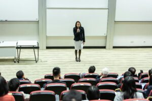 Businesswoman giving presentation to audience in lecture hall