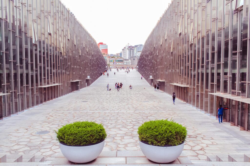 Modern walkway between glass buildings with people walking
