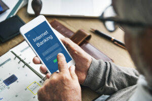 Person using a smartphone to access a mobile banking app, illustrating how UK student bank accounts offer convenient digital banking for managing everyday finances.