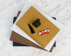 Graduation cap and diploma placed on academic documents