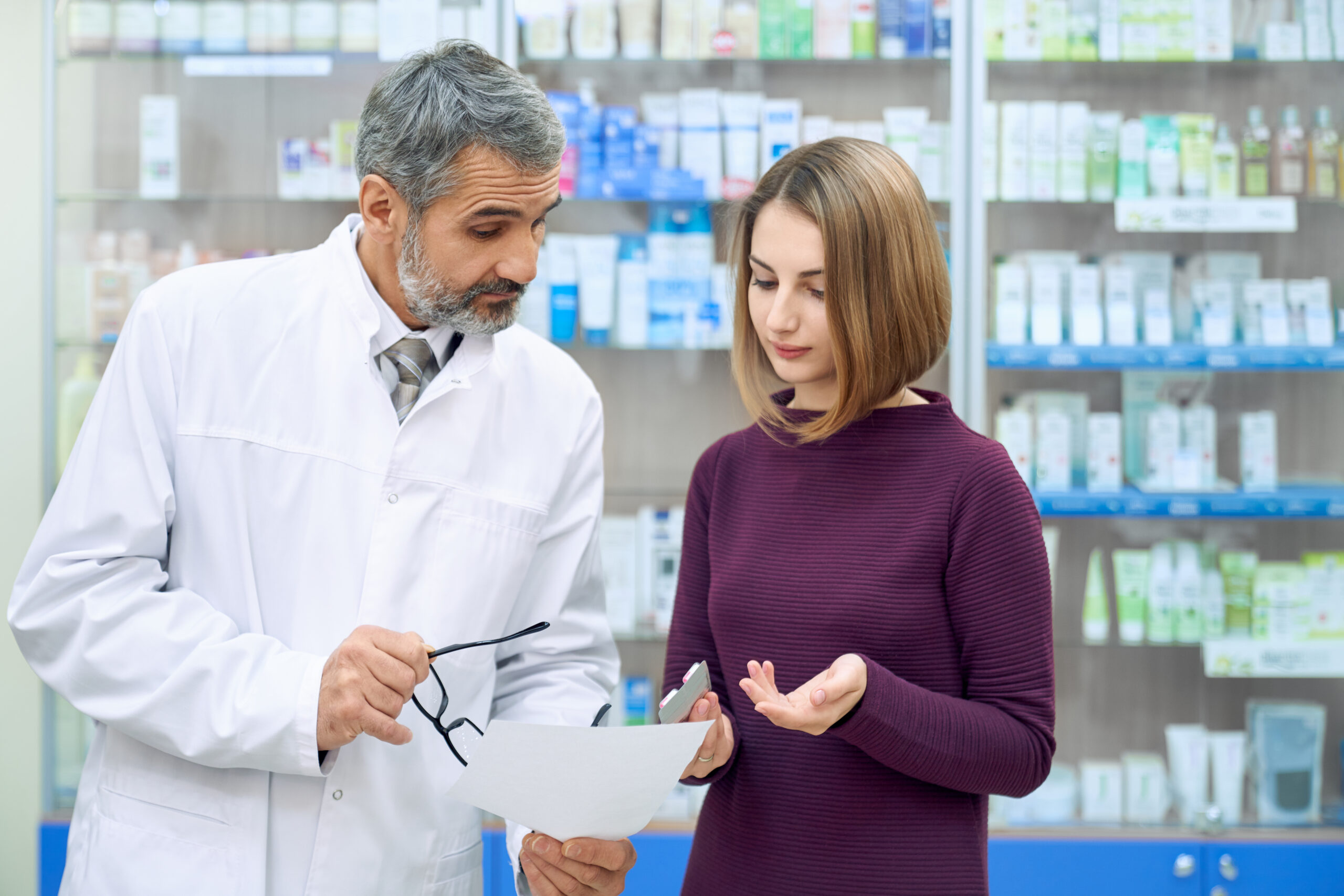 Pharmacist explaining prescription medication to an international student at a pharmacy