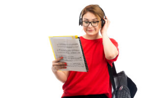 Student wearing headphones and reviewing study materials for an English language proficiency test